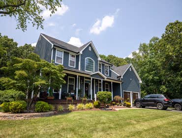 Blue Siding w/ Black Roof & Gutters Midnight blue siding, granite black roof, and black seamless gutters.