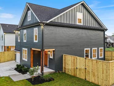 Side elevation shows fenced yard, covered entry, and durable exterior at 2703 Bronte Ave, Nashville by CJMC Build.