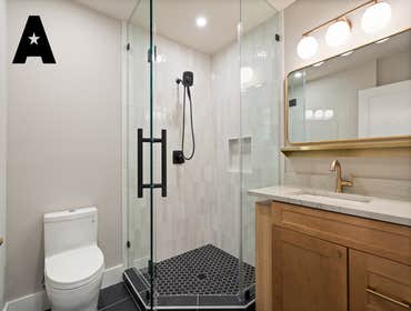 Modern Serenity - Luxurious Bathroom Remodel This bathroom remodel radiates modern elegance and thoughtful design. The frameless glass shower, with its