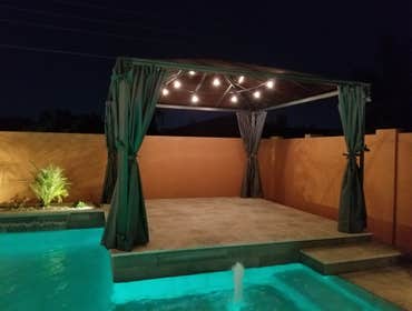Custom Pools Wet edge pool in phoenix with sun shelf, splash pad and hardscape/landscape.