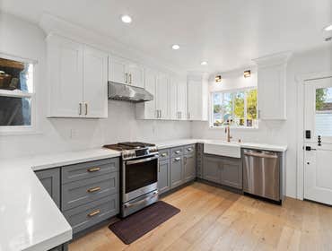 Modern kitchen design This full kitchen remodel features custom white and gray cabinetry, quartz countertops, a modern farmhouse sink, stainless steel 