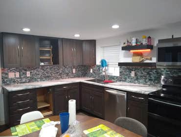 Photos by Patino's Remodeling LLC # Vic's Beautiful custom made kitchen , with epoxy countertop in white , lights under the cabinets , backsplash in gl