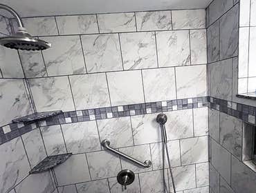 Brushed nickel fixtures and ADA compliant grab bars.