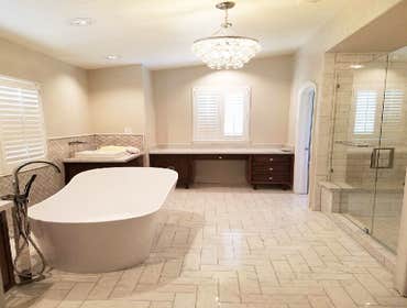Sleek bathroom Sleek bathroom remodel features freestanding bathtub paired with floor-mounted faucet atop marble floor placed in front of glass shower 