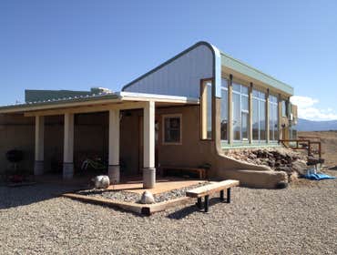 Little House Rammed Earth and Earth sheltered contemporary home. Passive solar heating, thermal mass, water harvesting and PV power system.