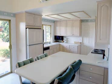 1990: Enjoyable Entertainment Kitchen This room originally had a very small cramped U-shape kitchen with a breakfast table for 4 in front of the slidin