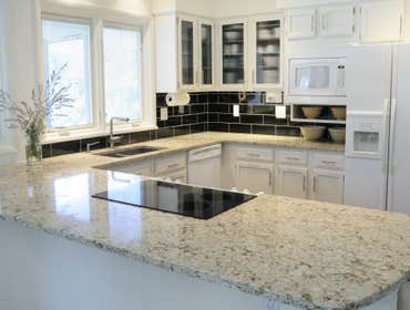 Modern White Kitchen We installed new cabinetry with some glass panel doors to create a more modern twist. This job had a very strict budget so the ca
