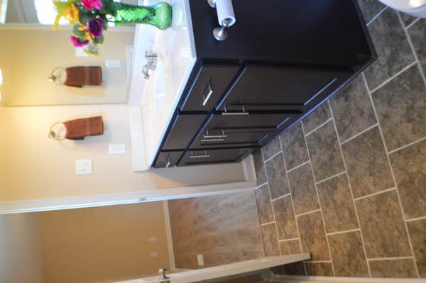 new tile floors, new vainy, toilet, shower with tile, new plumbing fixtures and new lighting