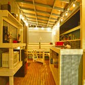 Outdoor Kitchen Added a roof, shelves, counters, sink, and a table to match existing benches and railing. This turned a master bedroom into a functiona