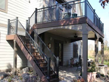 Custom Deck in Eden Prarie Trex decking in Lava Rock with ReadyRail Mid-Rail style aluminum railing, painted Miratec post wraps and arches, and Trex Ra