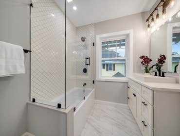 Photos by LCG BOSTON LLC #1 Full Home Remodel. Bathroom with custom glass, kitchen remodel with a beautiful exposed brick.