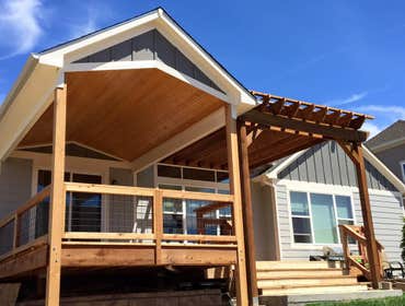 Fall Brook Patio Large multi-level deck with a portion of it covered by a solid cover and the other with a large pergola.