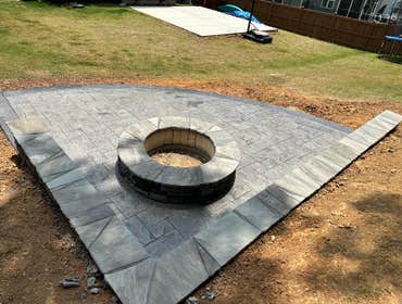 A stamped patio with his fire pit and sitting wall.