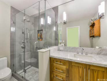 Photos by SFID Design Full remodel of two bathrooms, including new tiling, sinks, vanities, lighting, shower enclosures, also added a Bar Sink in the l