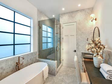 Hexagon Carrara Marble Bathroom The walls and floors of this master bathroom are enhanced with hexagon and chevron Carrara marble tiles, creating a lux