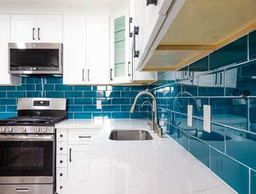 Pop of Color, Modern Designs A modern galley kitchen remodel featuring a timeless two-tone design. The upper cabinets in crisp white create a bright, o