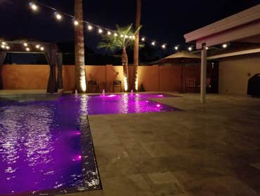 Custom Pools Wet edge pool in phoenix with sun shelf, splash pad and hardscape/landscape.