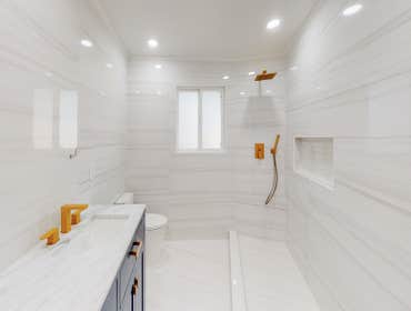 Saratoga Home Remodel This bathroom has blue hardwood cabinets, quartz countertop, undermount sinks, gold hardware, tile floors, tile walls, tile showe