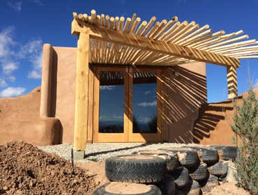 Tiny Workshop Built of rammed earth tires, masonry can and bottle work, and wood, we created a very small workshop for a couple of retired homeowners. 