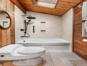Ed & Jill | Bathroom This rustic bathroom remodel features warm-toned tile walls that complement the wood accents throughout the space. We installed a 