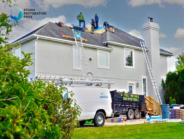Photos by Storm Restoration Pros LLC #1 Remove and replace the main roof, installation of a new gutter system, repair of a stucco wall.