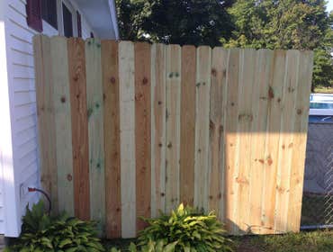 Wood fence Dog ear picket fence.All pressure treated wood, fence was built on site 1 picket at a time not bought in section.There used to be an existin
