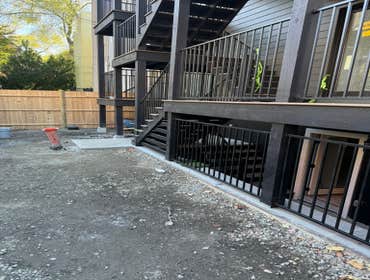 Triple Deck Full rear deck system for 3 family building with metal railings, composite decking and black stained frame