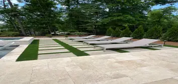 Huntersville Luxury Pool & Spa Project – Travertine, Turf, Landscaping & Lighting This high-end backyard transformation in Huntersville, NC features a 