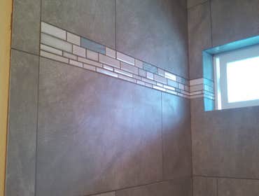 Eatonville Master Bath Beautifully done warm grey 12in x 24in porcelain tiles with a mosaic accent band and perfectly-set shampoo insert. Beautiful Mas