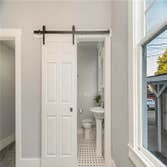Bathroom new tile, toilet, pedestal sink, shower and barn door for privacy