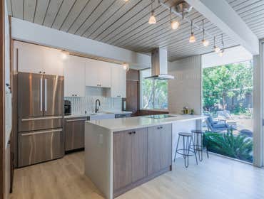 Mid Century Modern Kitchen Design This custom kitchen remodel is all about wow from the moment you walk in. It features a bold waterfall island with wa