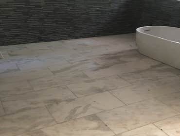 Bathroom tile floor and stone wall