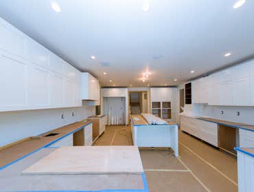 Kitchen Remodel Van Nuys This sleek contemporary kitchen features an aesthetically pleasing, neutral look with white shaker cabinets, a big island with