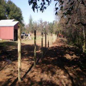 Fence Enclosure for Rescued Cats 850' of 6' high 2" x 4" fence with 5 gates. Project includes underground gopher wire along fence line to prevent coyo