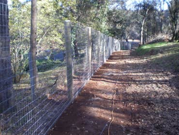 Fence Enclosure for Rescued Cats 850' of 6' high 2" x 4" fence with 5 gates. Project includes underground gopher wire along fence line to prevent coyo