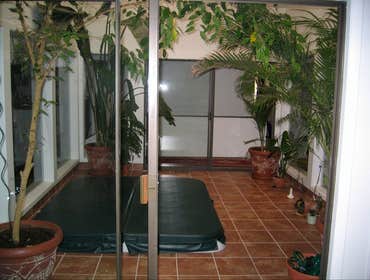 Atrium An atrium remodeled with a tile floor, a hot tub surrounded by glass walls