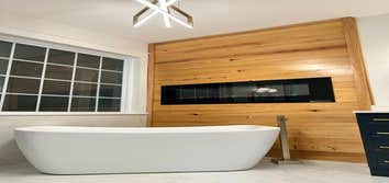 Photos by The Bathman #1 complete remodel, removed outdated corner tub and shower, installed wood accent wall, gas insert fireplace, tile shower & floo
