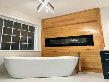 Photos by The Bathman #1 complete remodel, removed outdated corner tub and shower, installed wood accent wall, gas insert fireplace, tile shower & floo