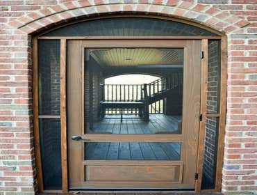 Screened Porch All cedar handrails and frame with hand-made laminated arches to maintain the beautiful, uncluttered view from inside.