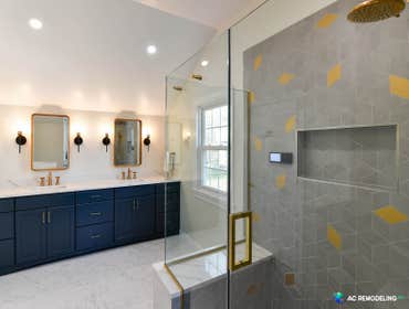 The Golden Master Bath We transformed this master bath into a bright and elegant space with golden fixtures and gorgeous blue cabinets. By opening up a