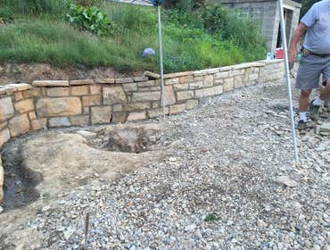 Photos from Hollis Contracting Tearing down the originally wall and replacing it with a nice stone wall. Along with a matching stone fireplace.