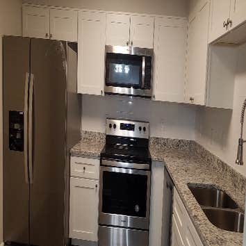 Photos by Combined Construction Services, Inc #1 Interior multi-family renovation including cabinets, countertops, flooring, paint, trim, and appliance
