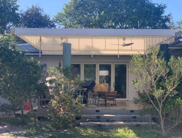 Photos by Sun Shade Miami #1 Backyard renovation including deck, concrete columns, cut wall to add larger door, fixed waterproof awning