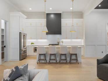 Kitchen overview with large island, paneled fridge, and custom hood completed by CJMC Build in 12 South, Nashville.