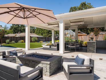 Full Outdoor Kitchen & Entertainment Custom designed pergola with kitchen, dining and seated area with retractable screens and heaters. Fire pit area.