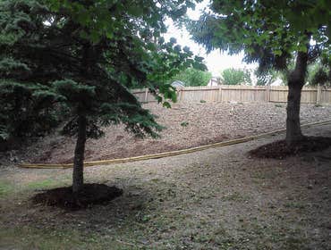 Lego Services - Bank Landscape Remove weeds, overgrown grass, and rock.
Replaced with landscape fabric, single ground mulch, and Blue Rug Junipers.