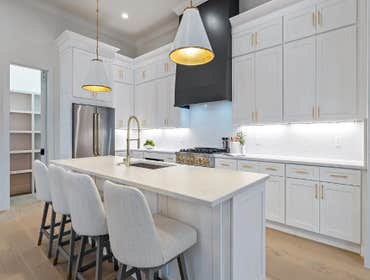 Entertainer kitchen with tall cabinets, quartz island, and brass accents as part of the addition by CJMC Build in 12 South, Nashville.