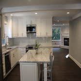 Kitchen Remodel Kitchen transformation including marble counter tops, custom white cabinets, dark stained natural hardwood flooring, glass tile back sp