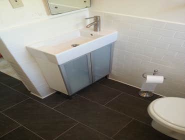 Full bathroom remodel Subway tile shower with accent strip and wainscot with 12x24 tile on the bathroom floor