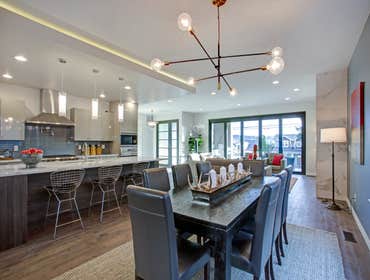 Sleek modern kitchen design with a kitchen peninsula fitted with a gray and white quartz counter top.